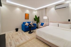 ein Schlafzimmer mit einem großen Bett und einem blauen Stuhl in der Unterkunft 402 Elegant Studio with Self Check-in Al-Salmaniyah Neighborhood in Riad