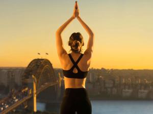 een vrouw in bikini die yoga doet op de top van een gebouw bij The Sebel Quay West Suites Sydney in Sydney
