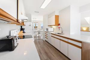 een keuken met witte kasten en een aanrechtblad bij CAC-18B - Snapper in Buxton +34 foto's