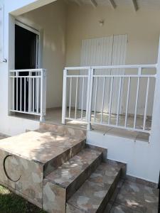 a porch with white railings and stairs in a house at Orchidé in Sainte-Anne +5 photos
