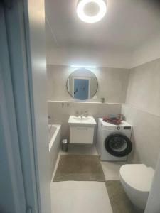 a bathroom with a sink and a washing machine at Apartmán P121 in Trnava