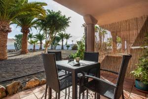 un tavolo e sedie su un patio con palme di Coral Bliss a Corralejo