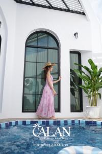 a little girl in a pink dress standing next to a swimming pool at ALAN Pool Villa Bangsaen อารัญ พูลวิลล่า บางแสน in Ban Bang Saen (1)