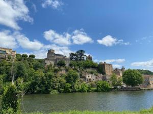 a castle on top of a hill next to a river at Gite Deja Vu in Montcabrier