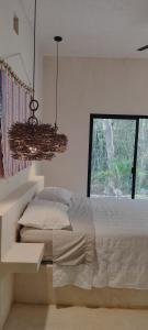 une chambre blanche avec un lit et une fenêtre dans l'établissement Casabel Tulum jungle experience, à Cobá