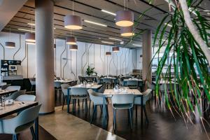 a restaurant with tables and chairs and plants at Clarion Congress Hotel Ústí nad Labem in Ústí nad Labem
