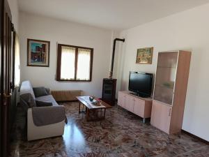 a living room with a couch and a tv at Al Centrale in Alano di Piave +7 photos