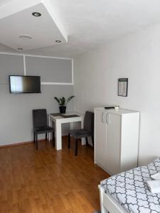 een slaapkamer met een bed, een tafel en stoelen bij Sobe kod bolnice Paprikovac in Banja Luka