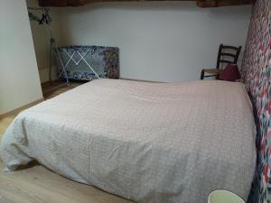 a bedroom with a bed with a white comforter at Gîte Chez Dédé in Brillac
