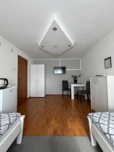 a living room with two beds and a dining table at Sobe kod bolnice Paprikovac in Banja Luka