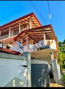 a house with a porch with a fence and a gate at Ranu Villa kathaluwa in Elagawagoda