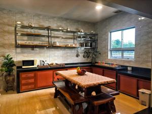 a large kitchen with a table and a sink at Entire Villa, Ferry Terminal Pickup & Breakfast in Batam Center