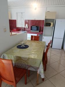 サンタンヌにあるOrchidéのテーブルと椅子と冷蔵庫のあるキッチン