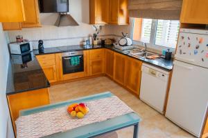 a kitchen with a table with a bowl of fruit on it at Verde Verdilhão Villa 