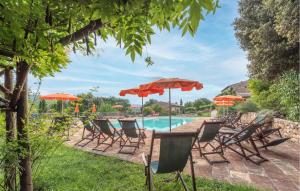 a group of chairs and umbrellas next to a pool at Cozy Apartment In Casole D'elsa With Wifi in Gallena +16 photos