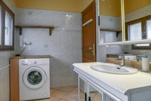 een badkamer met een wasmachine en een wastafel bij Nature et Calme Entre Deux Lacs in La Biolle