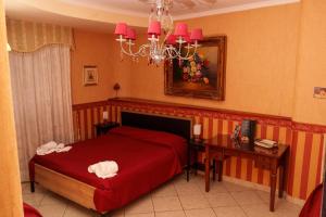 a bedroom with a red bed and a table and a chandelier at B&B VILLA BELLA in Catanzaro