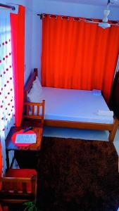 a bedroom with a bed with an orange curtain at Phee home in Mombasa