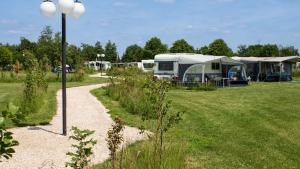 Un grupo de tiendas de campaña en un campo con una farola en Resort Veldhoven, en Veldhoven