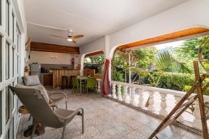 Habitación con balcón con sillas y mesa. en Beau Bamboo, en Mahe