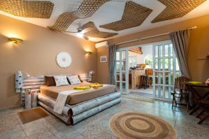 Un dormitorio con una cama y una sala de estar. en Beau Bamboo, en Mahe