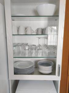 a cabinet filled with plates and cups and dishes at Casa céntrica en Girona in Girona