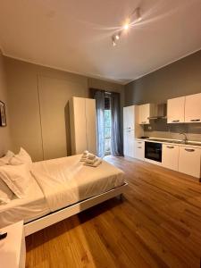 a large bedroom with a bed and a kitchen at Hermoso Housing Tortona in Tortona