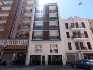 un grand bâtiment avec une voiture garée devant dans l'établissement il tuo bnb bovio28 - Full home e Park, à Bari