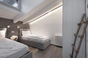 a small bedroom with two beds and a window at Mansarda Angel's Home in Ponte di Legno