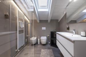 a bathroom with a sink and a toilet and a window at Mansarda Angel's Home in Ponte di Legno +26 photos