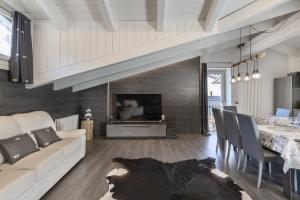 a living room with a white couch and a table at Mansarda Angel's Home in Ponte di Legno