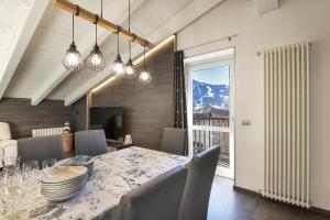 a dining room with a table and chairs and a window at Mansarda Angel's Home in Ponte di Legno