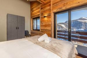 a bedroom with a bed with a mountain view at Penthouse Croix de Coeur in Riddes