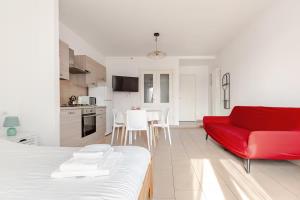 a living room with a red couch and a kitchen at Casa Angela Apartments in Bergamo