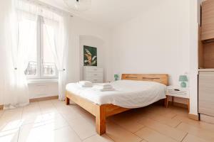 a white bedroom with a bed and a window at Casa Angela Apartments in Bergamo