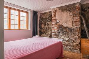 a bedroom with a bed and a brick wall at Franshammars vandrarhem in Hassela