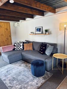 een woonkamer met een grijze bank en een tafel bij Old Stone Byre in Totaig