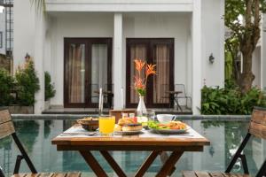 a table with food and drinks on it next to a pool at Villa Ban Hien in Hiếu Nhơn
