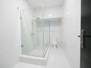 MagodoにあるKaypoint Homesのシャワーとトイレ付きの白いバスルーム