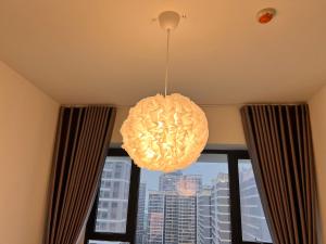 a light hanging from a ceiling in a room with a window at Vinhomes Grand Park Homestay-Masterise Homes Center in Long Bình