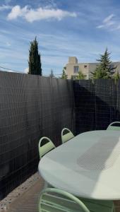 a table and chairs on a patio with a fence at Centrale climatisée deux chambres terrasse parking, saint raphael in Saint-Raphaël