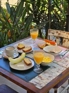 a picnic table with breakfast foods and drinks on it at Pousada Quintal das Hortênsias in Salesópolis