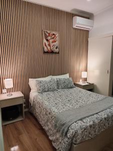 a bedroom with a bed and two tables with lamps at HOSPEDARIA LONDRES in Porto