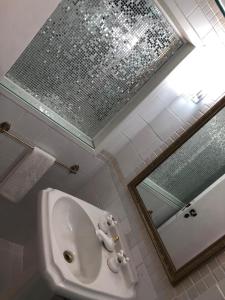 a bathroom with a sink and a mirror at Pousada Quintal das Hortênsias in Salesópolis