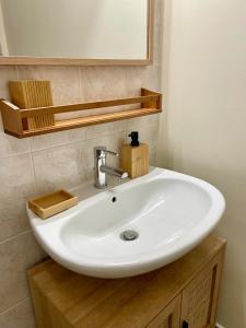 a white sink in a bathroom with a mirror at AppartCosy 20 Maison proche "La Régalante" in Landavran +25 photos