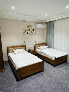two beds in a hotel room with two bedsvisor at Muhammad in Andizhan