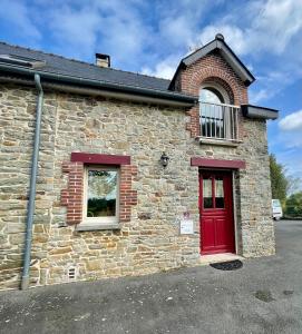 a brick building with a red door at AppartCosy 20 Maison proche "La Régalante" in Landavran