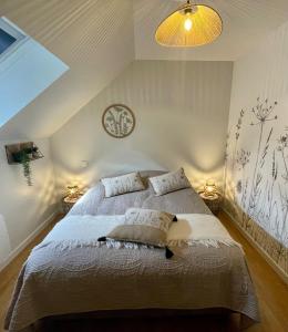 a bedroom with a bed with two pillows on it at AppartCosy 20 Maison proche "La Régalante" in Landavran