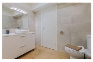 a white bathroom with a sink and a toilet at Ladadika Vibes Apartments 2 in Thessaloniki