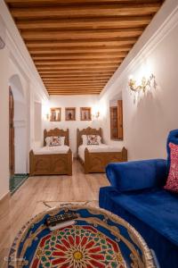 a living room with a blue couch and a bed at Dar Chama in Chefchaouene +60 photos
